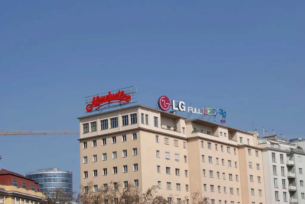 An Almdudler advertising sign on top of an apartment block.