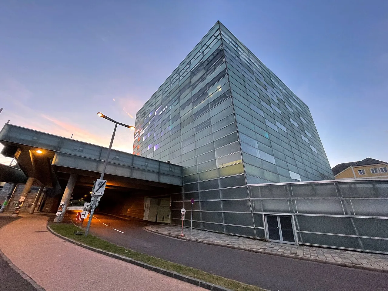 The glass facade of the Ars Electronica Center in Linz at dusk.