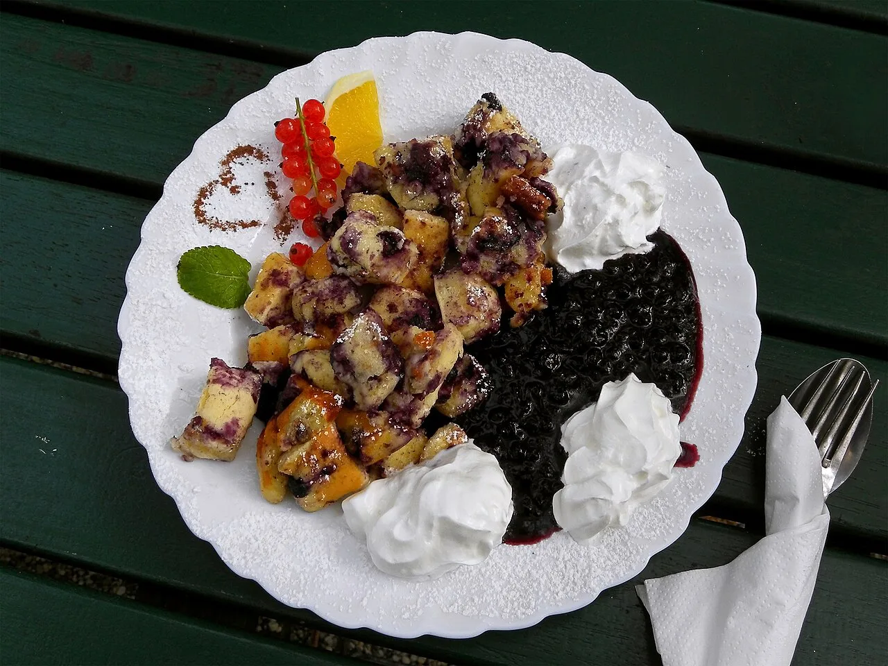 Heidelbeerschmarrn, a blueberry version of Kaiserschmarrn, with elderberry compote and whipped cream.
