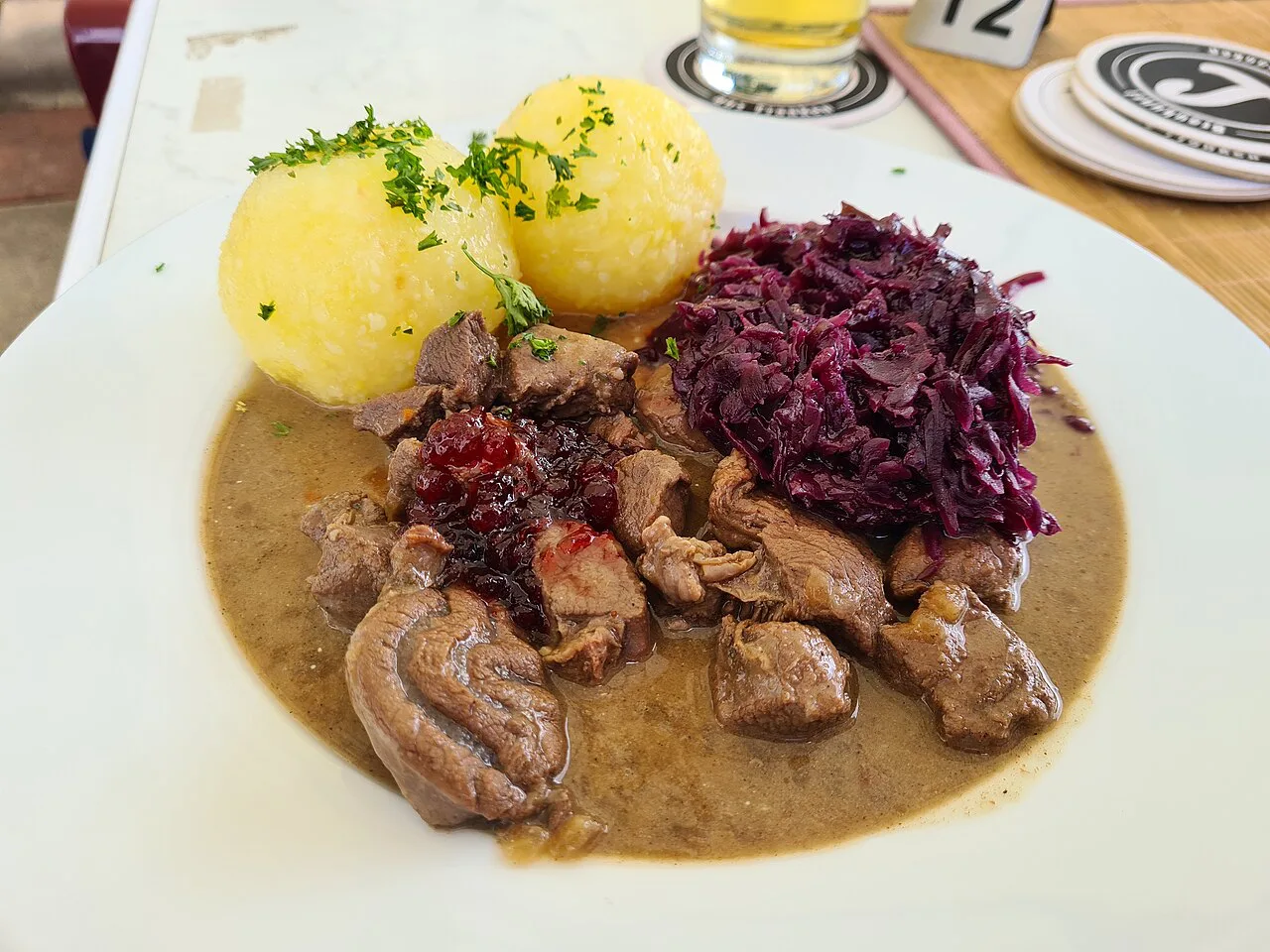 Venison goulash with red cabbage, potato dumplings and cranberries.