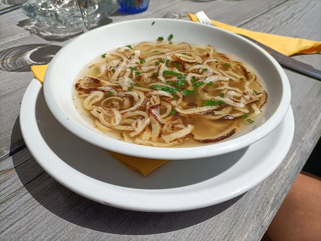 Frittatensuppe with pancake strips and chives, served outdoors.