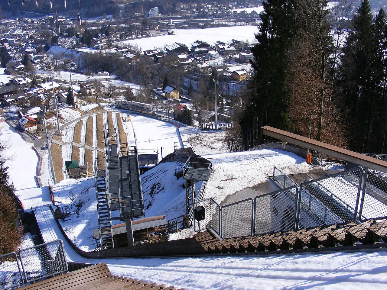 Looking down a ski jump towards the town of Bischofshofen in winter.