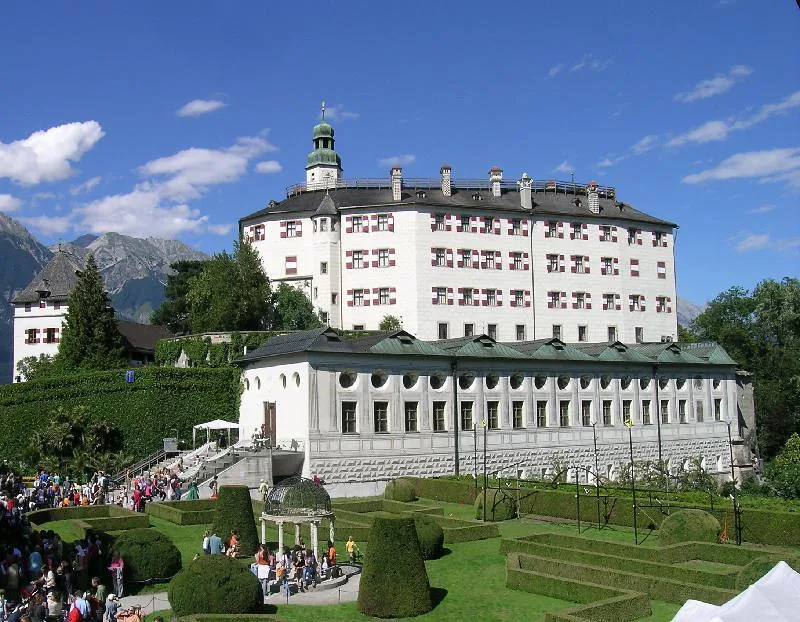 The white upper castle of Schloss Ambras above its formal gardens in Innsbruck.