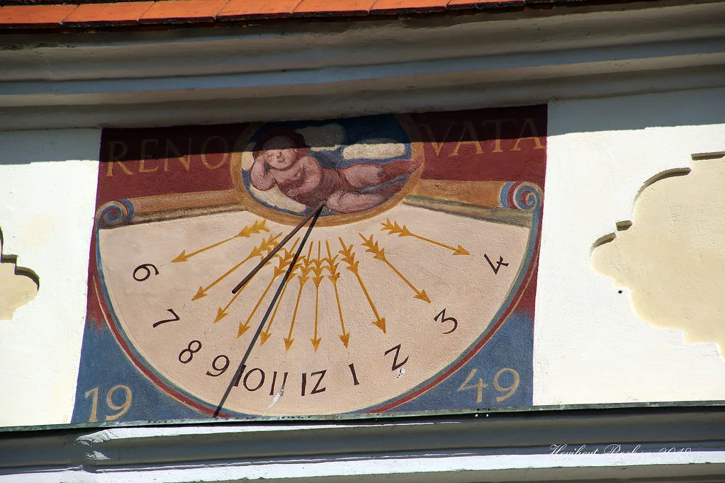A painted sundial on a building wall in Eisenstadt.