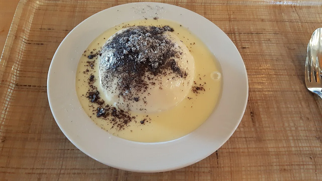 Germknödel topped with poppy seeds in vanilla sauce.