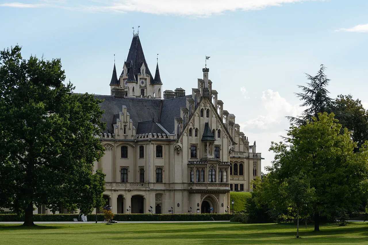 The towers of Grafenegg Castle framed by trees in the castle park.