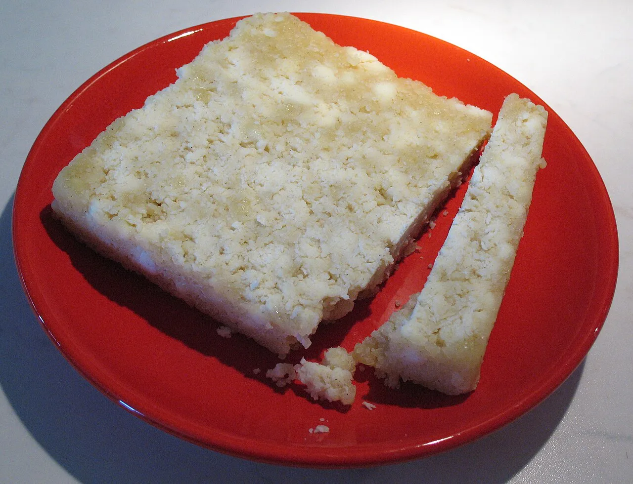 A slice of Tyrolean Graukäse on a red plate.