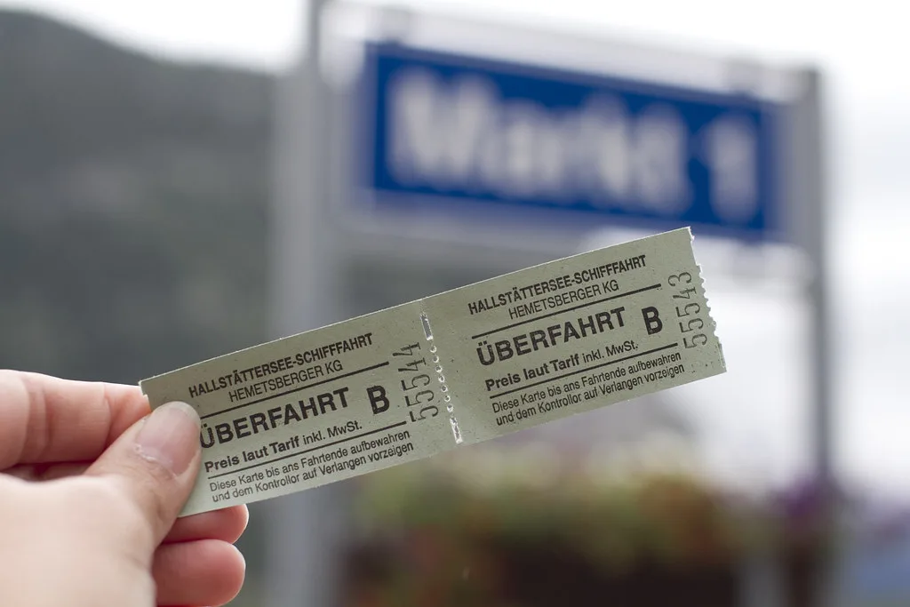 A Hallstättersee ferry ticket for the crossing to Hallstatt, held up in front of a Markt sign.