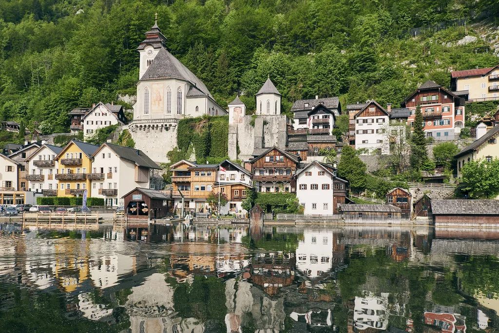 Hallstatt's church and houses reflected in Lake Hallstatt.