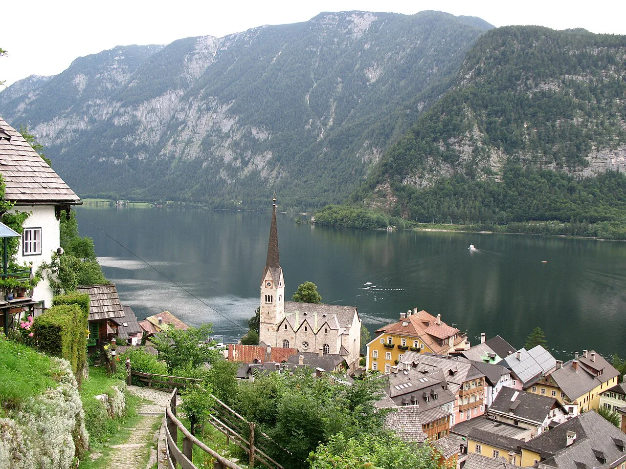 Hallstatt and its lake, with the slender spire of the Protestant Christuskirche by the shore.