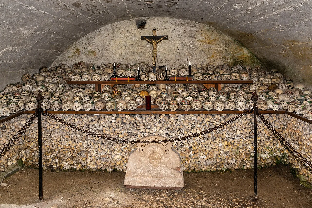 Rows of skulls stacked beneath a crucifix in the Hallstatt ossuary.