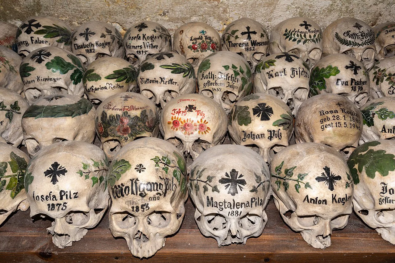 Painted skulls bearing names and floral motifs in the Hallstatt ossuary.