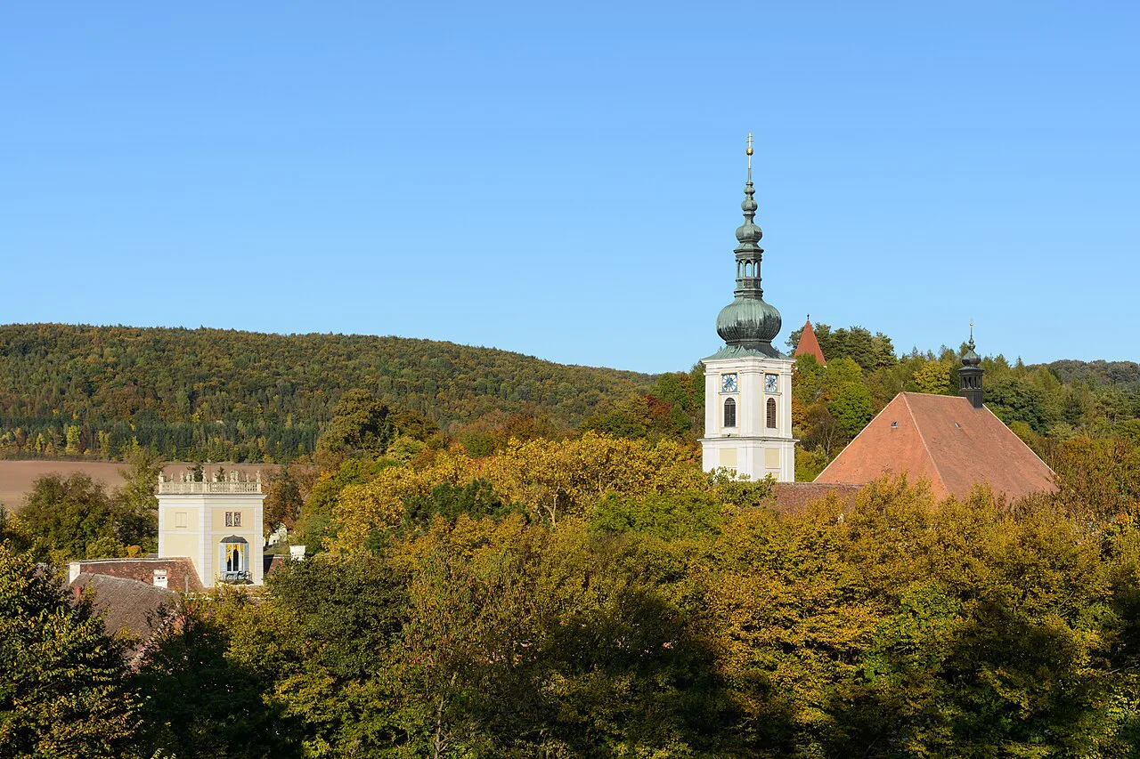 Tower and church of Heiligenkreuz Abbey among autumn trees in the Vienna Woods.