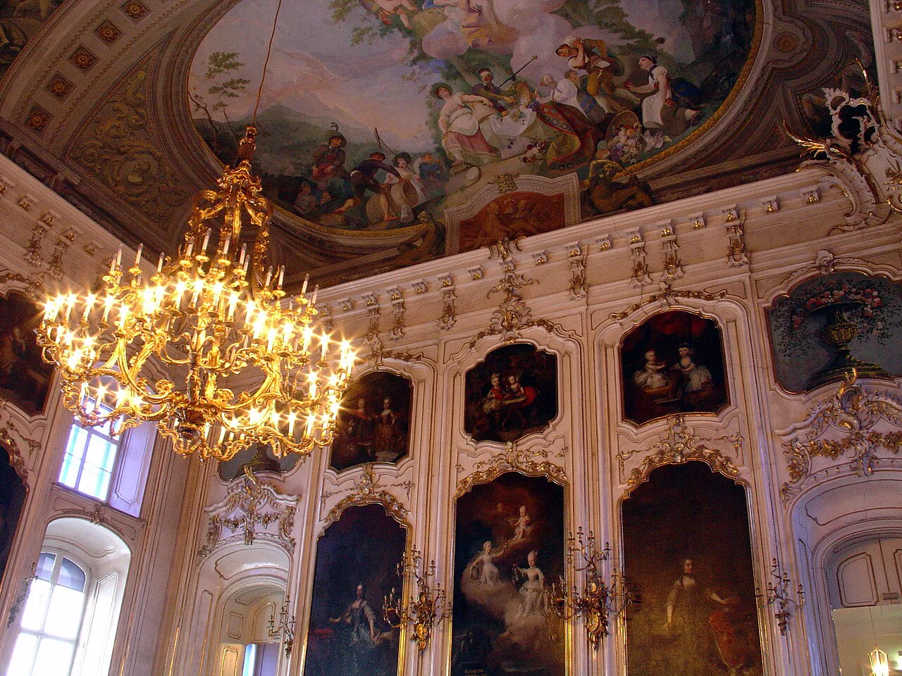 The Giants' Hall in Innsbruck's Hofburg with its ceiling fresco and chandeliers.