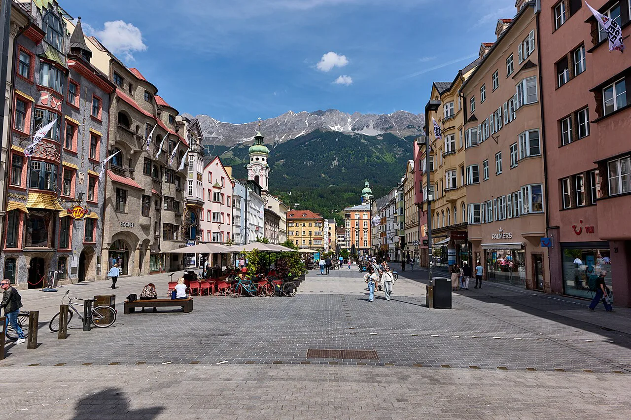 Maria-Theresien-Straße in Innsbruck, with mountains rising beyond the townhouses.
