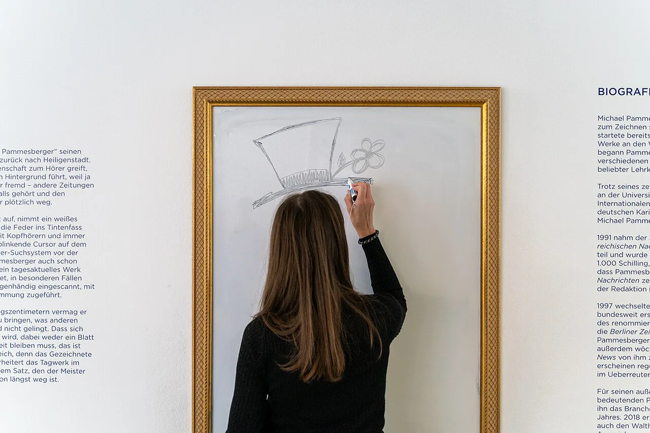 A visitor drawing on an exhibition wall inside the Karikaturmuseum Krems.