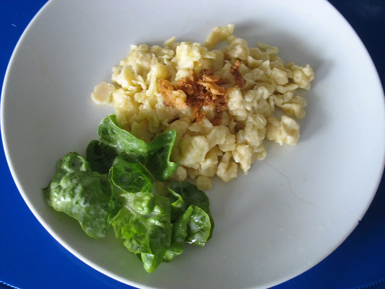 Käsespätzle served with a green salad.