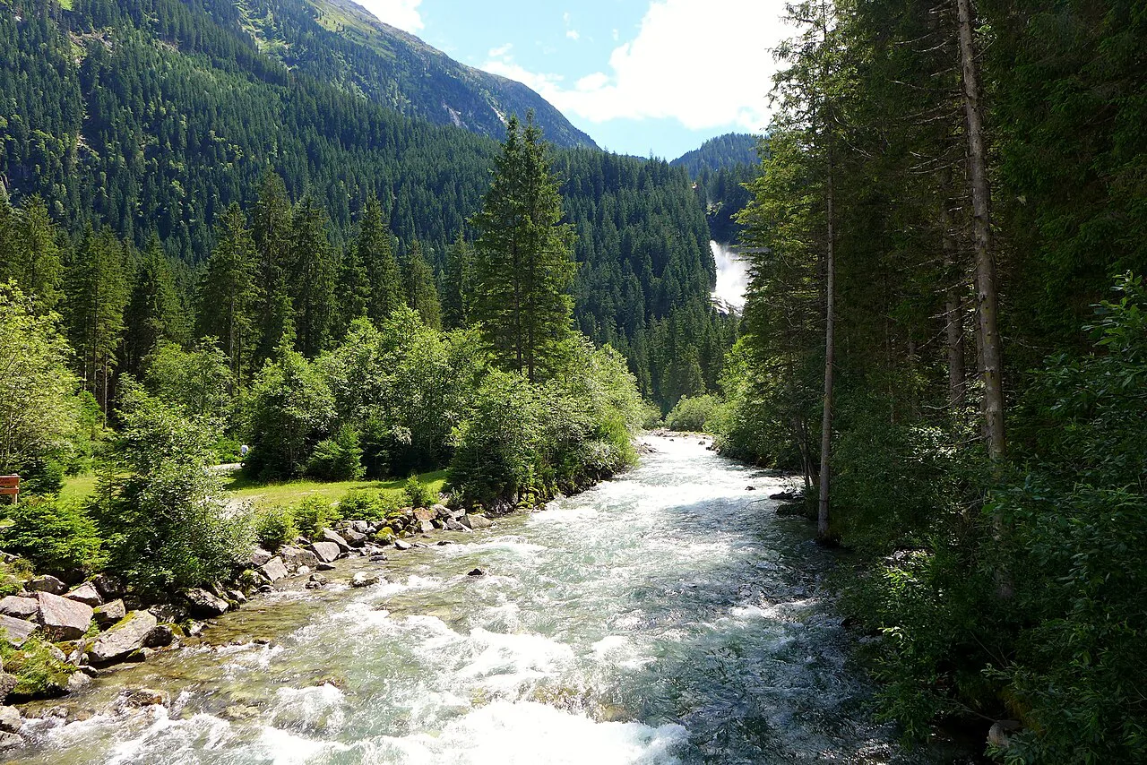 The Krimmler Ache in its forested valley, with the Krimml Waterfalls in the distance.