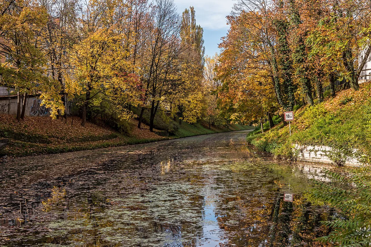The Lendkanal in Klagenfurt lined with autumn trees.