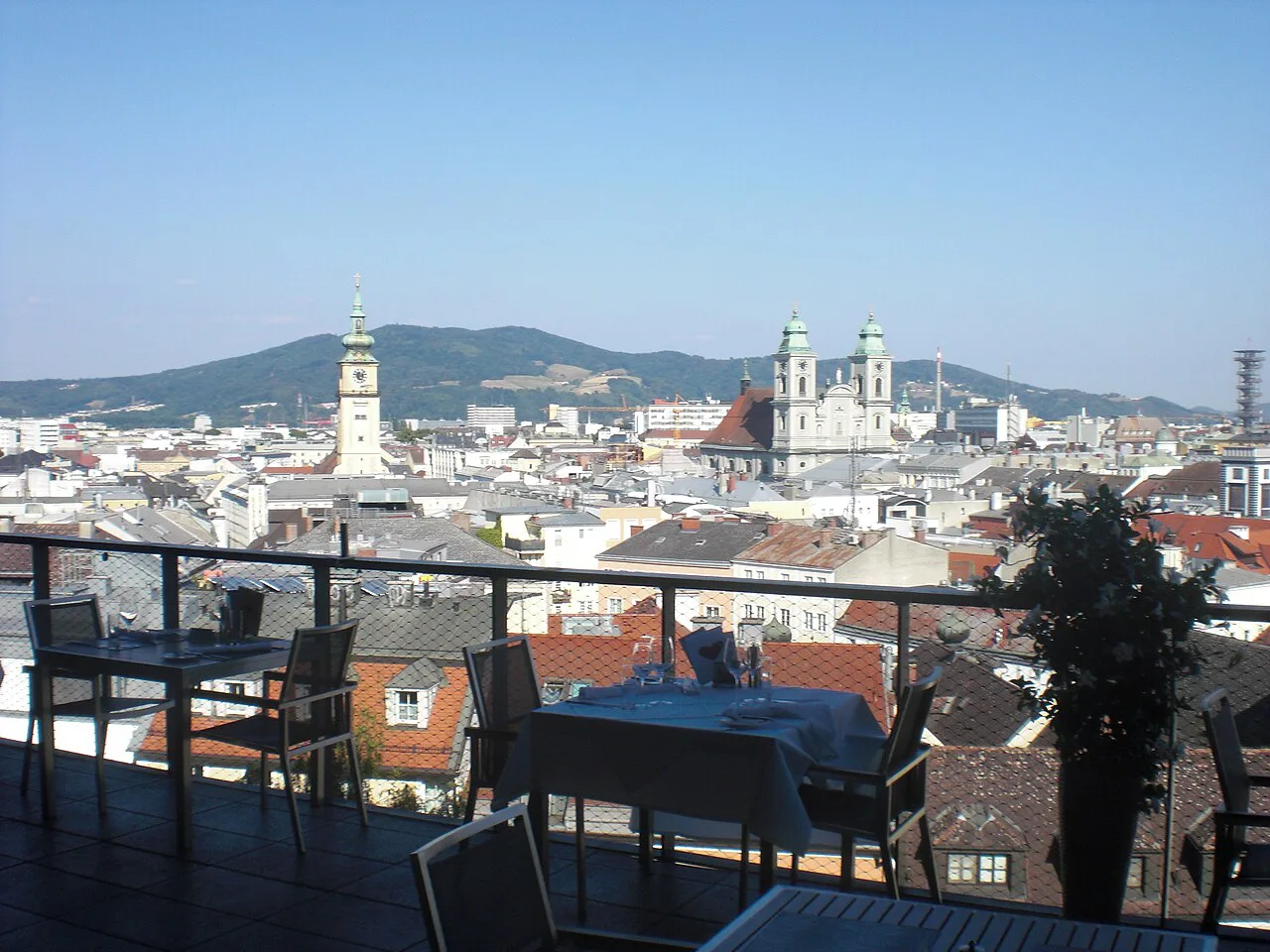 Panorama of central Linz and its church towers from a rooftop terrace.