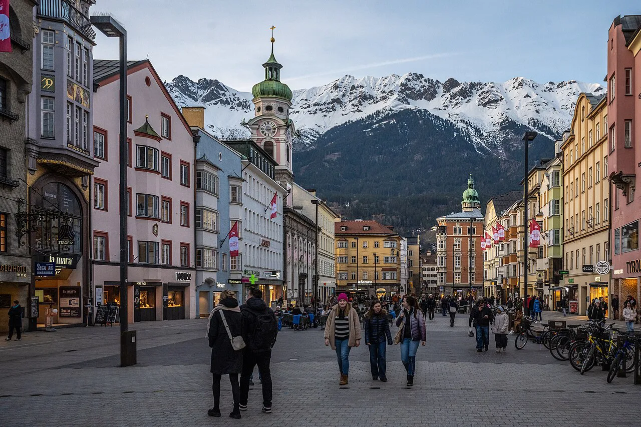 Maria-Theresien-Straße in Innsbruck with snowy mountains behind.