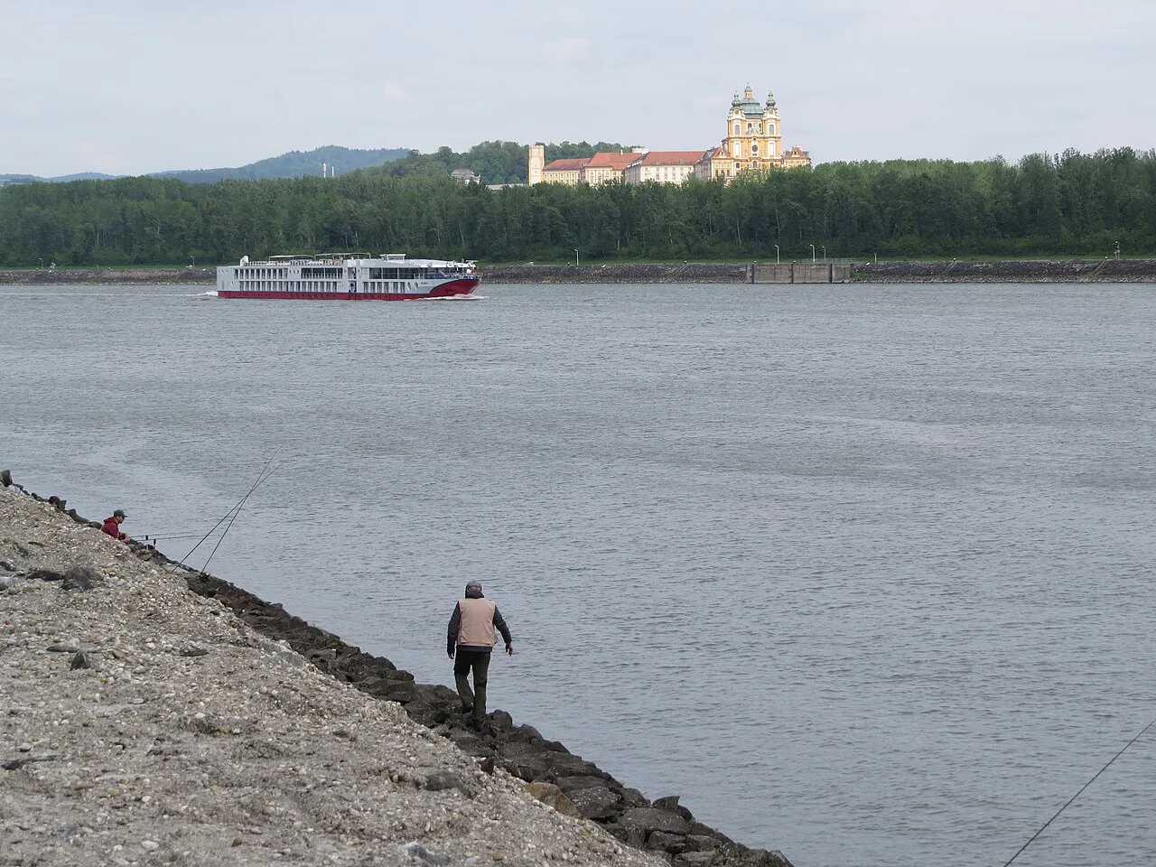 A river cruise ship on the Danube, with Melk Abbey on the hill behind.