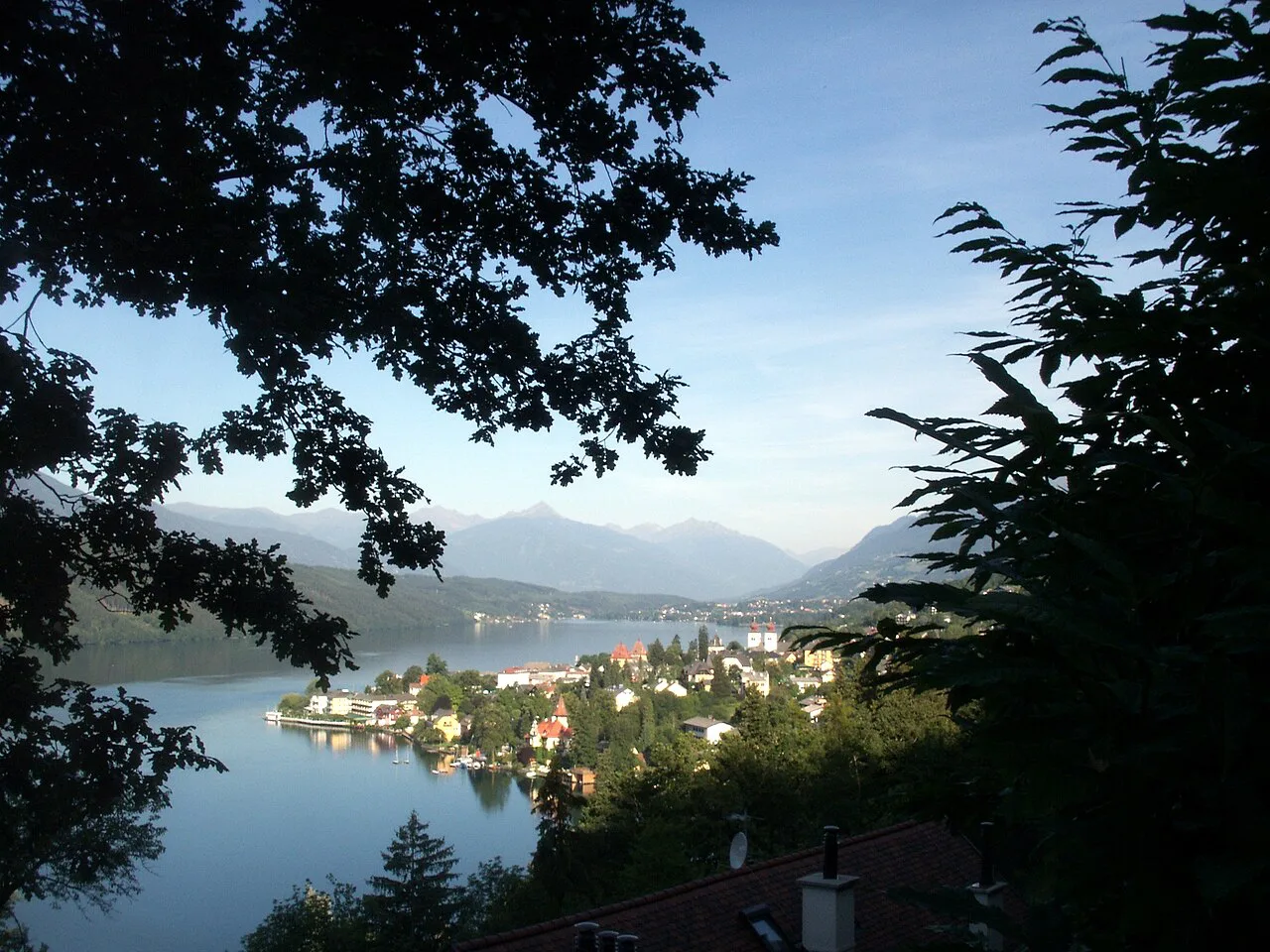 Millstatt's lakeside houses on the Millstätter See framed by trees.