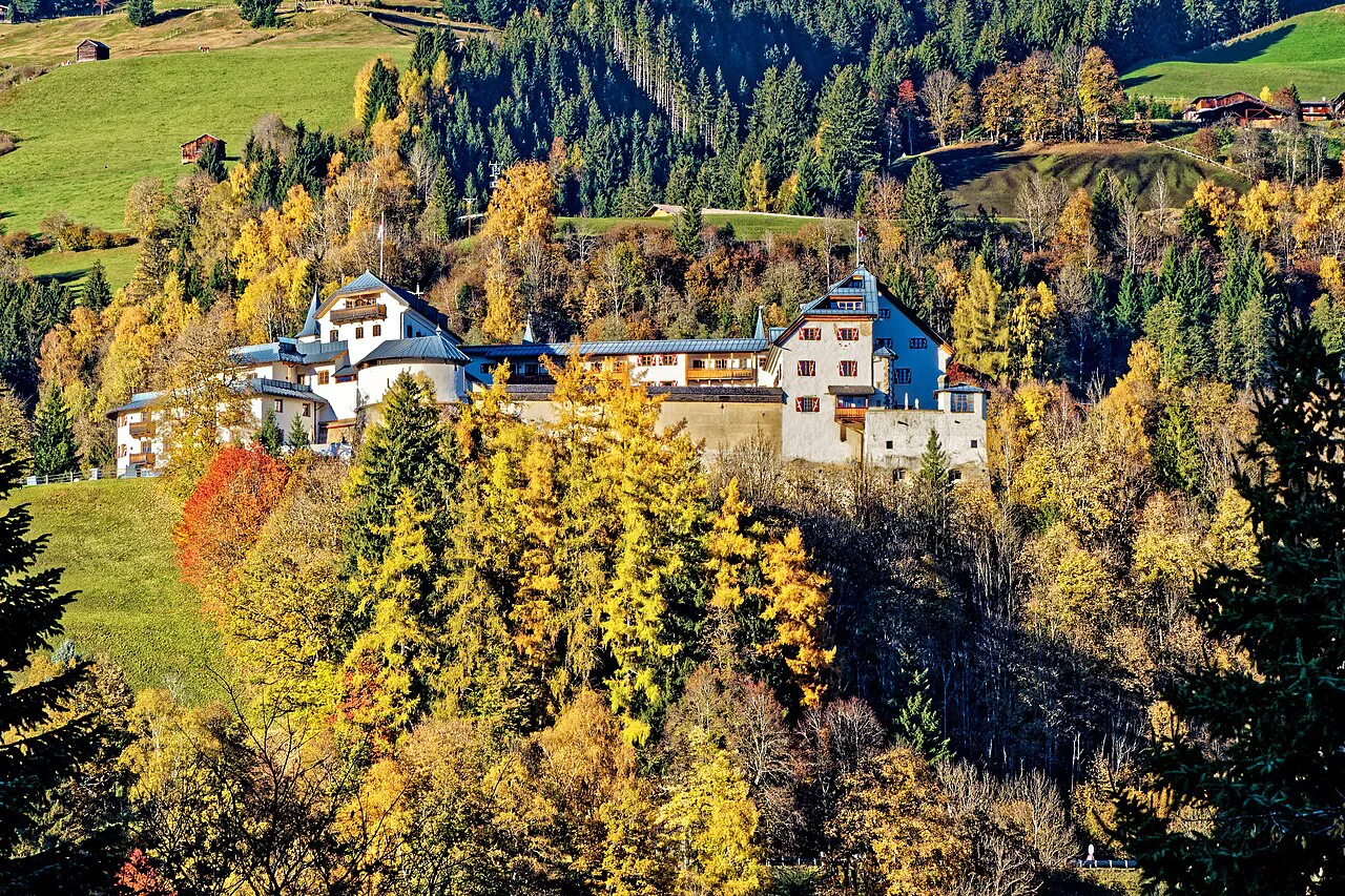 Buildings on the wooded slope above Mittersill in autumn colour.