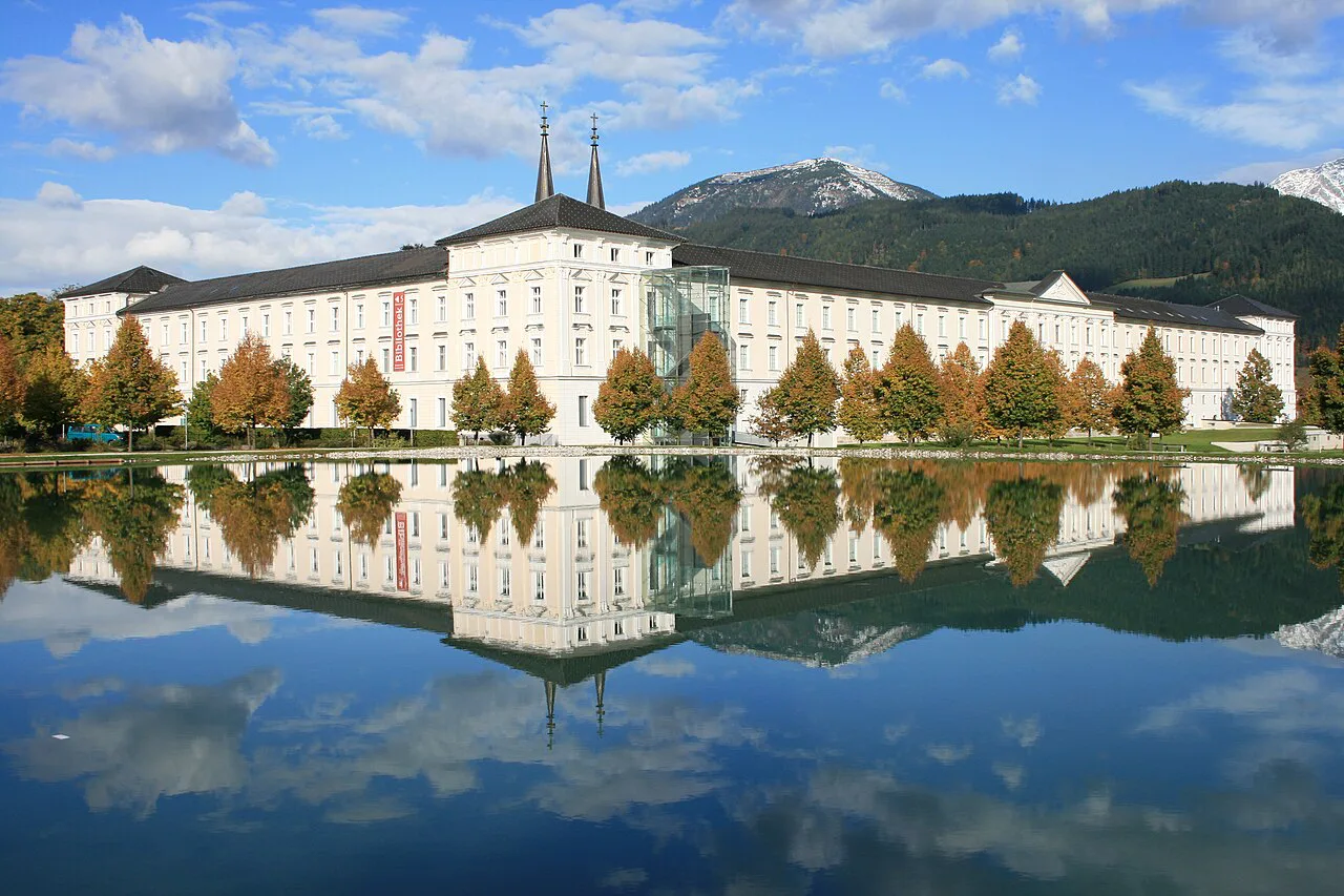 Admont Abbey reflected in a pond below the mountains.