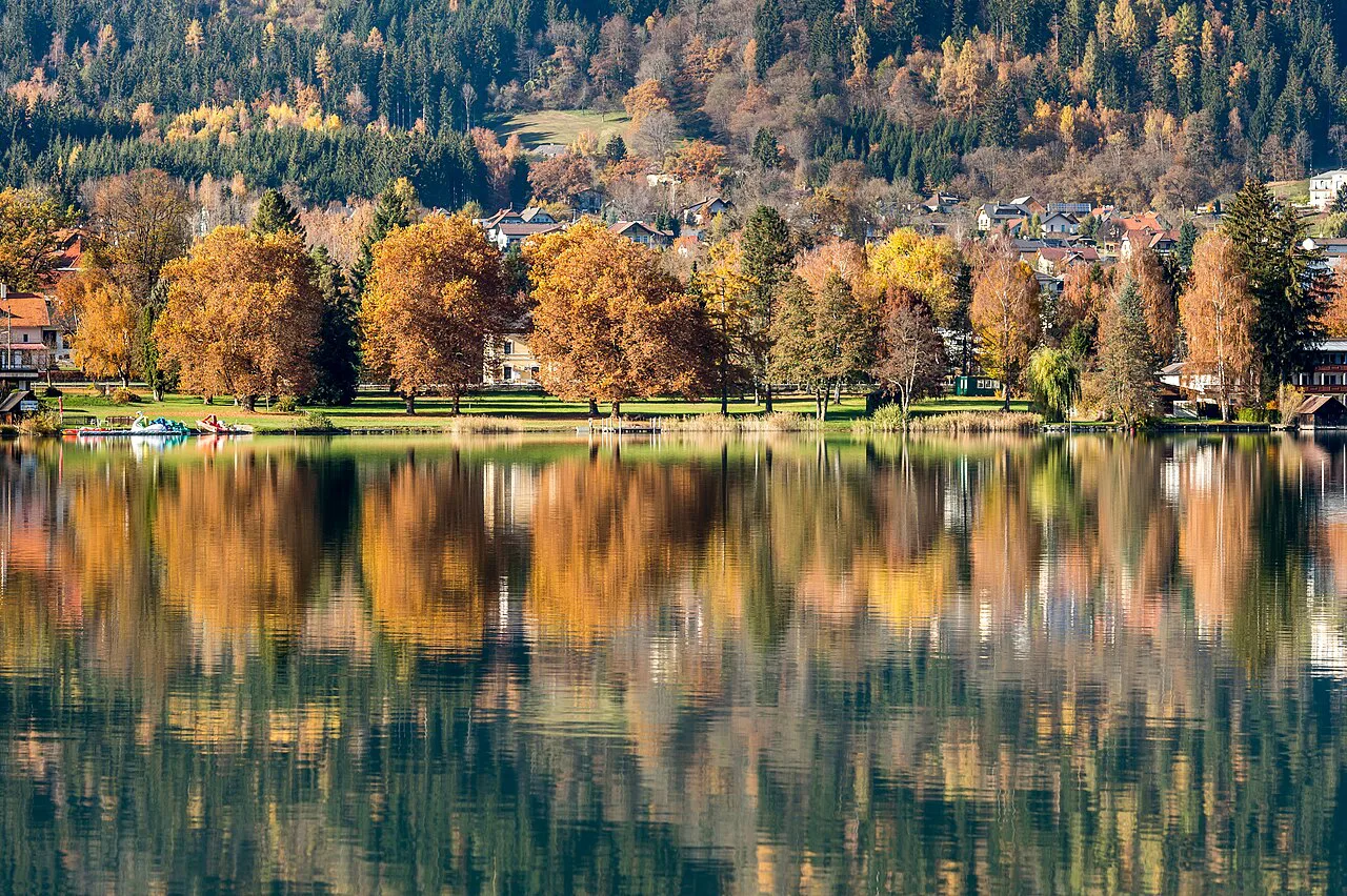 Autumn trees reflected in the Ossiacher See at the Toff lido in Bodensdorf.