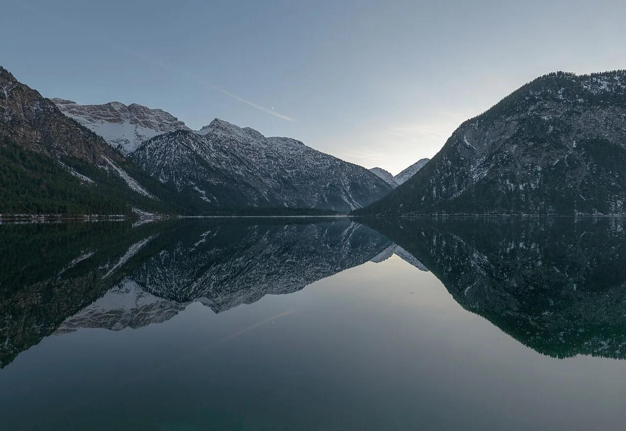 Mountains reflected in the still water of the Plansee near Reutte.