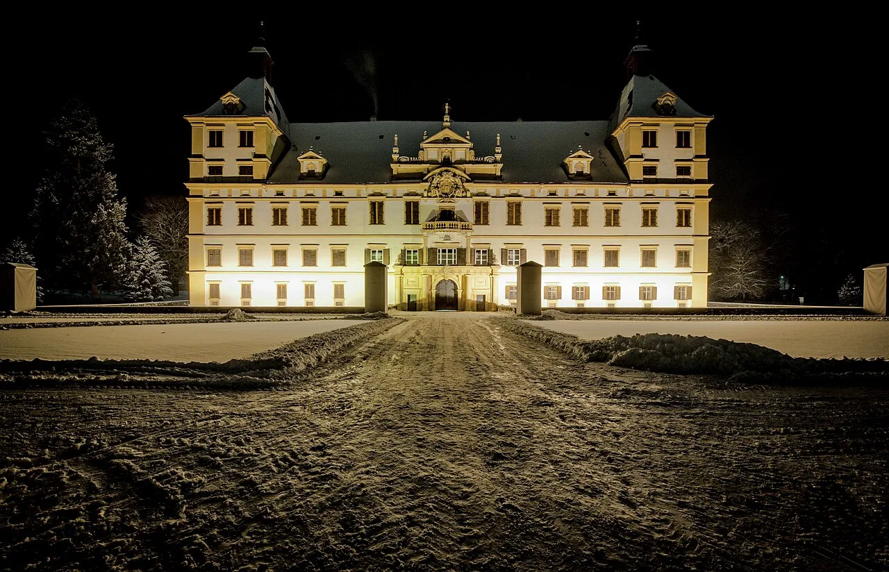 Eggenberg Palace in Graz lit up on a snowy night.