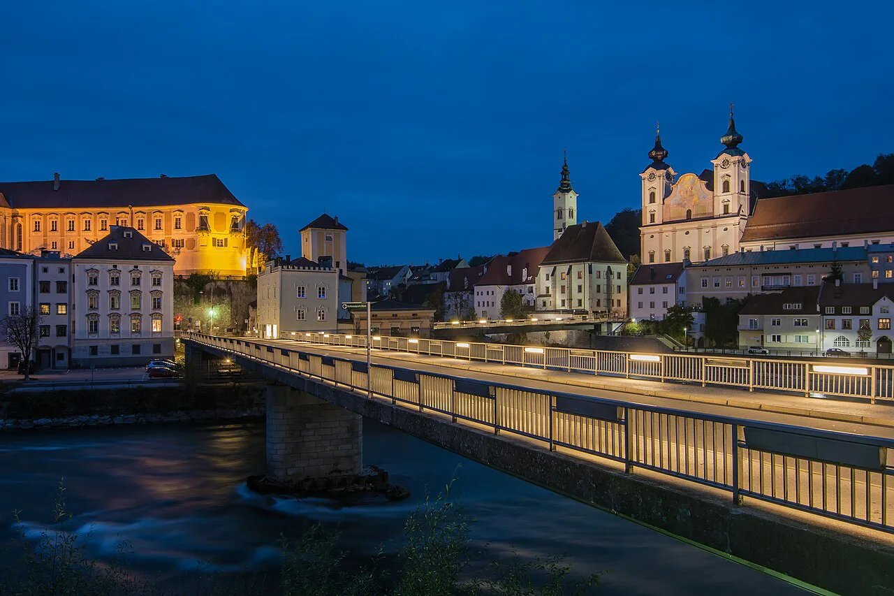 Schloss Lamberg and St. Michael's Church above the river in Steyr at dusk.