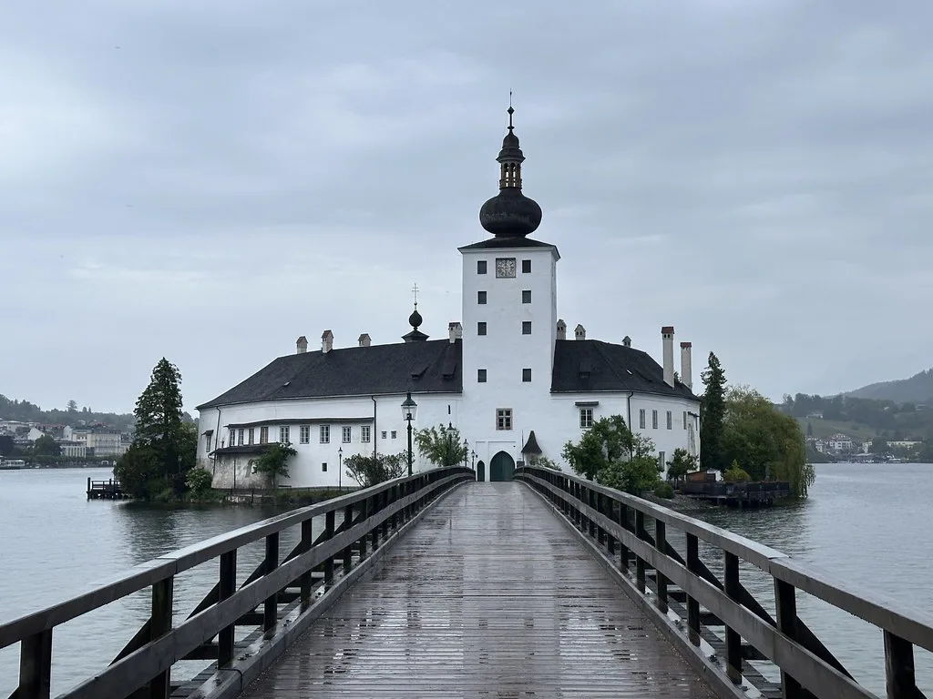 Venue view: wooden bridge leading to Schloss Ort castle on Lake Traunsee in Gmunden, Austria.
