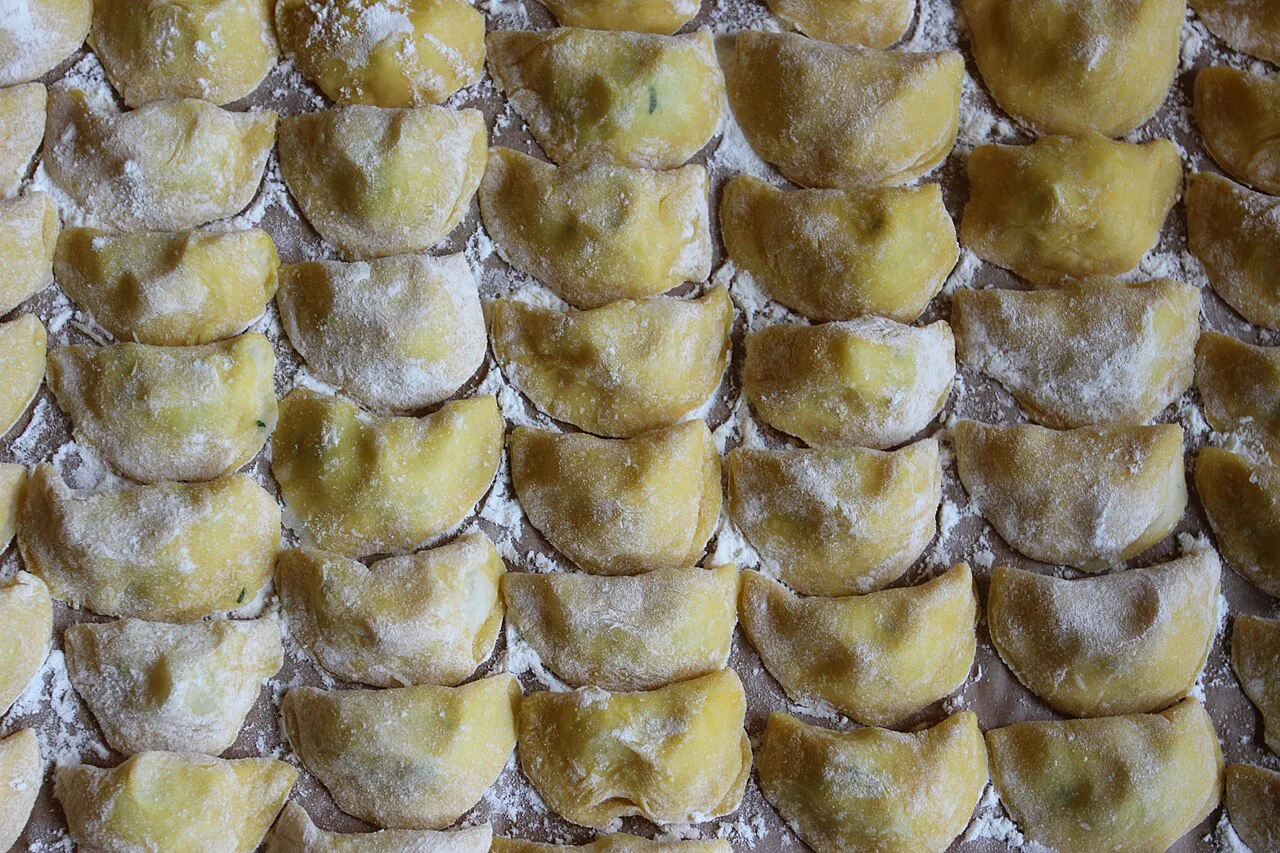 Rows of uncooked Schlutzkrapfen dusted with flour.