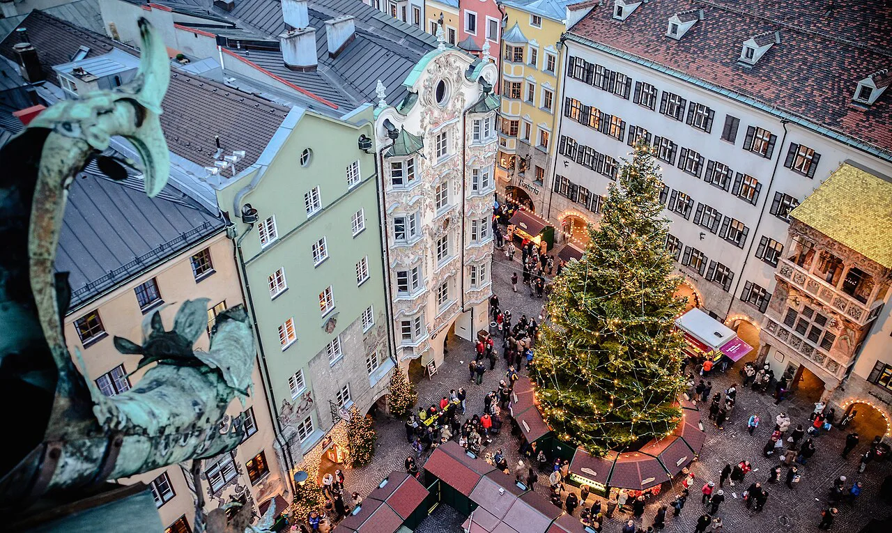 Christmas market around a decorated tree in Innsbruck's old town, with the Goldenes Dachl at right.