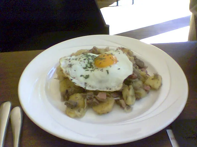 A plate of Tiroler Gröstl topped with a fried egg.