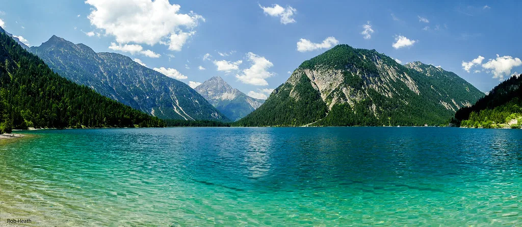 The clear turquoise water of the Plansee in Tyrol, framed by mountains.