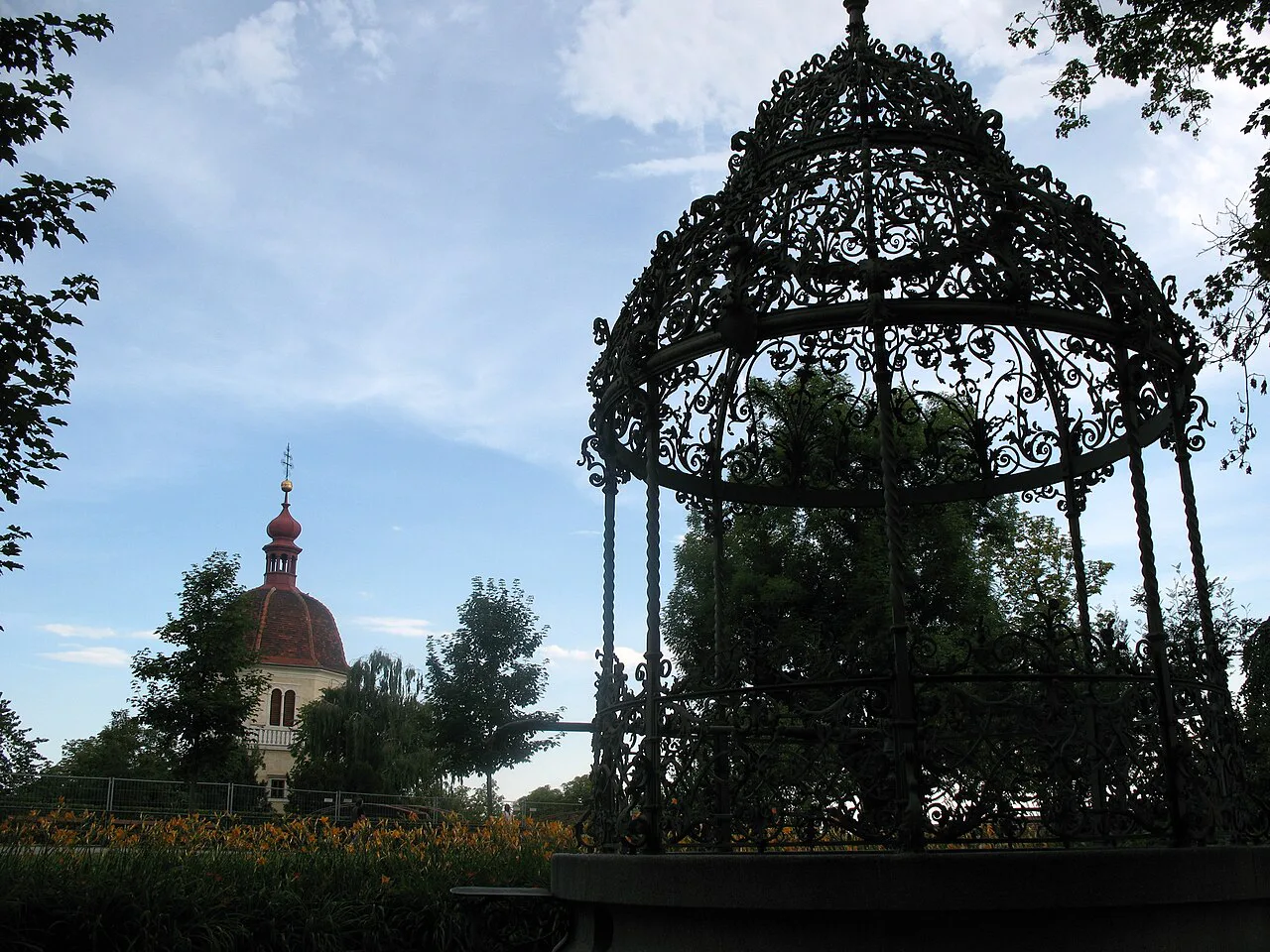 A wrought-iron well canopy on Graz's Schlossberg, the hill crowned by the Clock Tower.