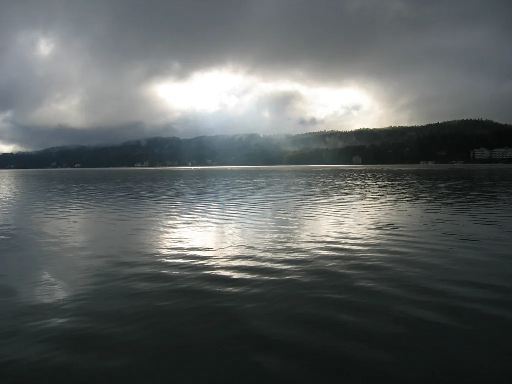 Dawn light breaking through cloud over the Wörthersee, seen from Velden.