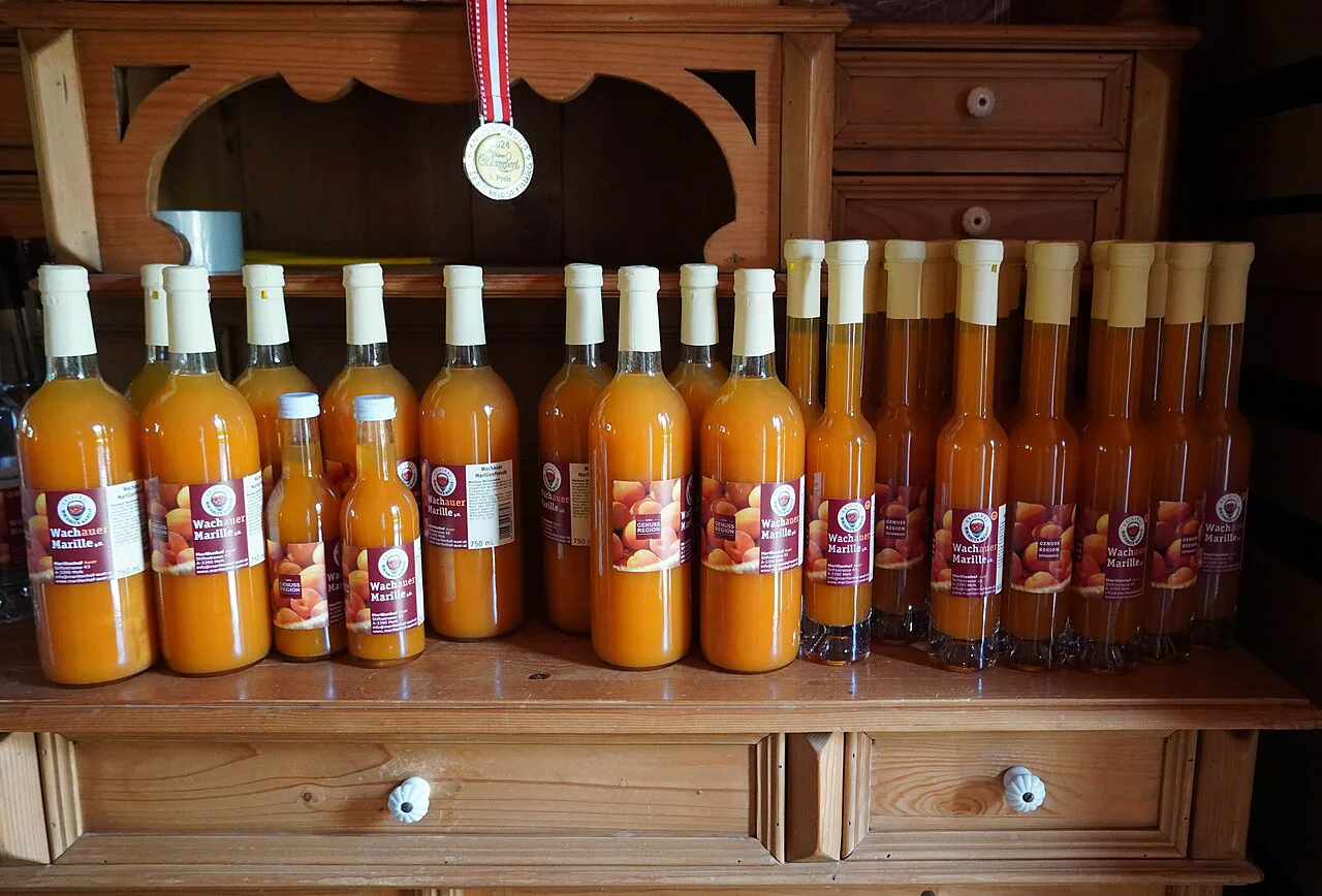 Bottles of Wachau apricot nectar lined up on a wooden dresser.