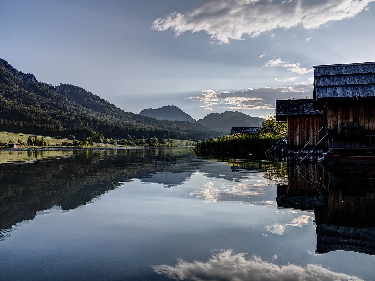 A boathouse and mountain reflections on the Weissensee at Techendorf.