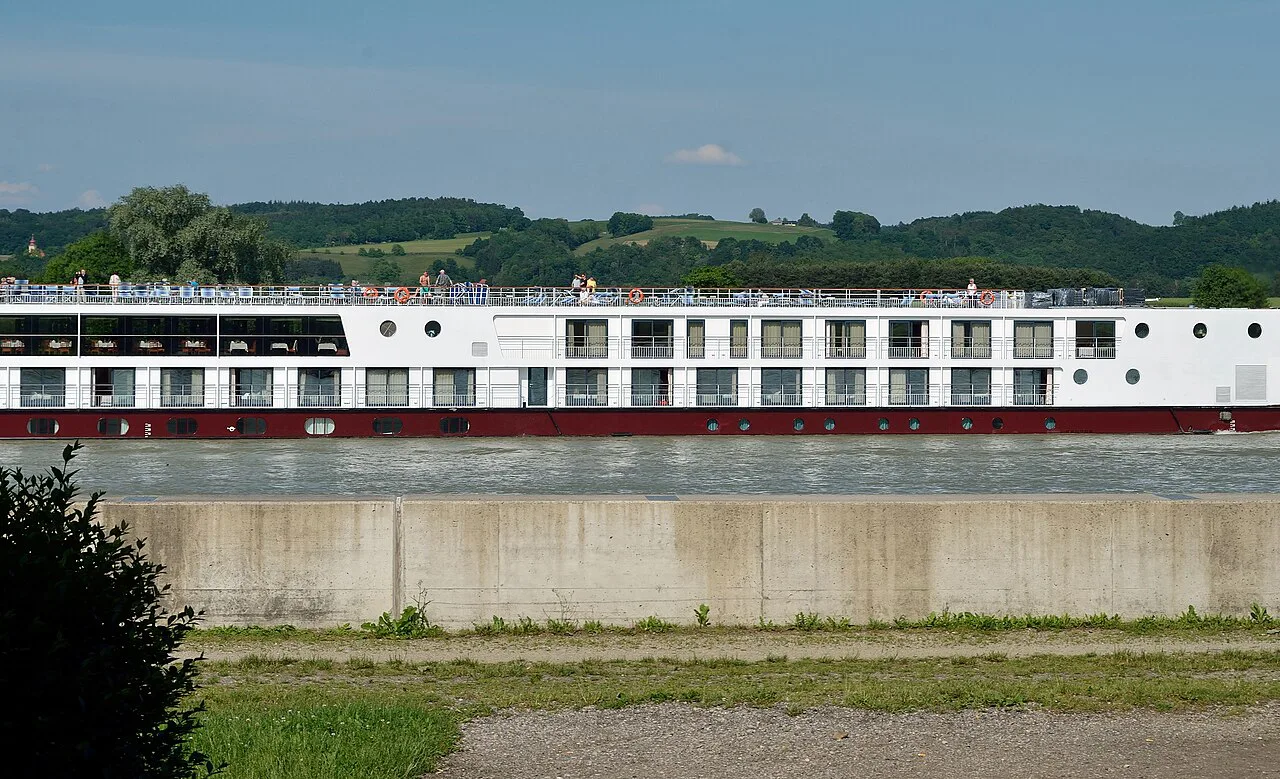 A river cruise ship passing Ybbs an der Donau beside the flood defences.